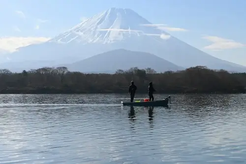 早春に山梨県精進湖より望む富士山と釣り舟